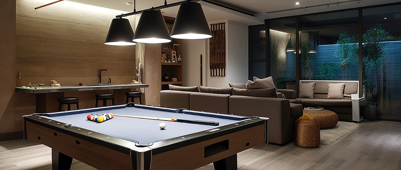 Large lounging area with a pool table, bar seating, and sofas.